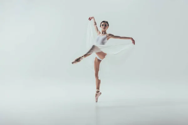 Молодая элегантная балерина танцует в студии, изолированная на белом — стоковое фото