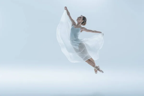 Elegante ballerina in abito bianco che salta in studio, isolata su bianco — Foto stock