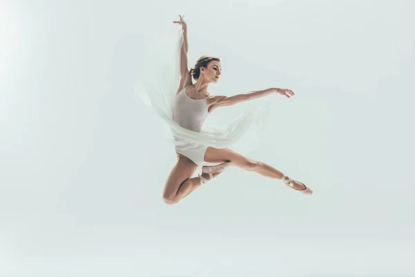 Jovem bailarina elegante em vestido branco pulando em estúdio, isolado em branco — Fotografia de Stock