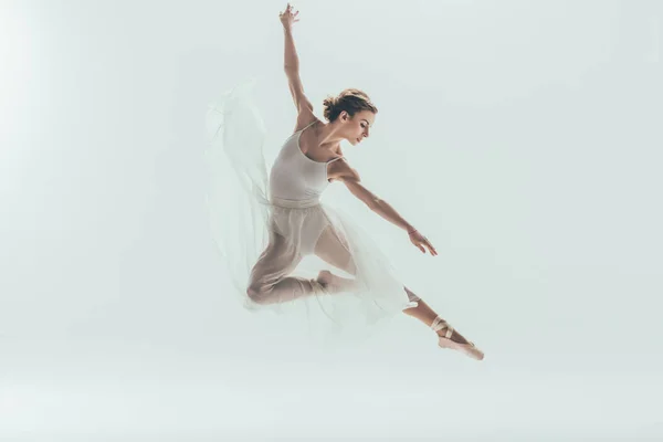 Hermosa bailarina de ballet en vestido blanco saltando en el estudio, aislado en blanco - foto de stock
