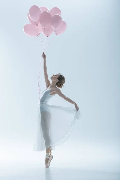 Elegante Balletttänzerin im weißen Kleid mit rosa Luftballons, isoliert auf weiß — Stockfoto