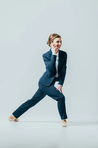 Femme d'affaires en costume et chaussures de ballet parlant sur smartphone, isolé sur gris — Photo de stock