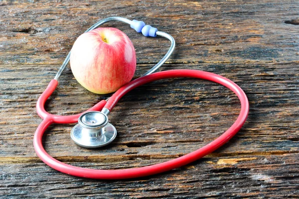 Ein Stethoskop hinter dem Apfel für gesundes Holz — Stockfoto