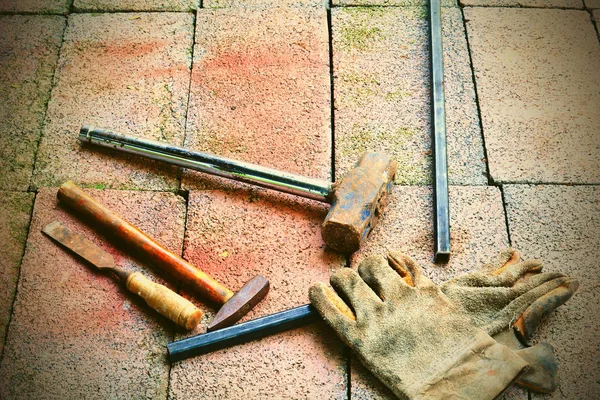 The gloves, hammer, chisel, steel stick and shoes put on brick