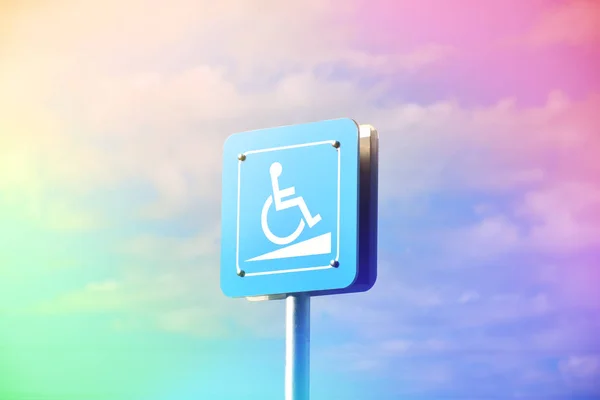 Blue sign or steel accessible sign in public under the blue sky