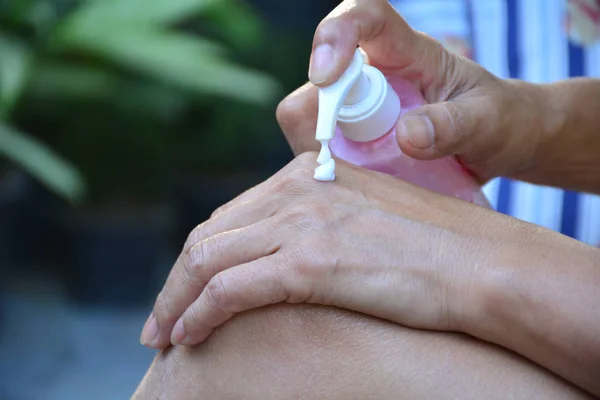 hand of woman  apply lotion on skin of  back hand