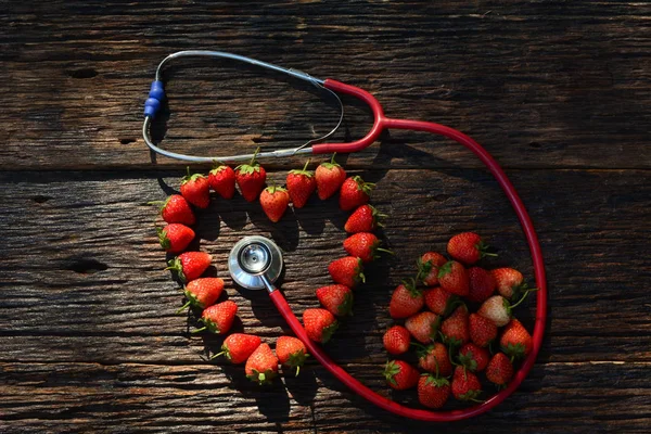 Stéthoscope et coeur de fraise pour en bonne santé sur écorce de vieux bois ba — Photo