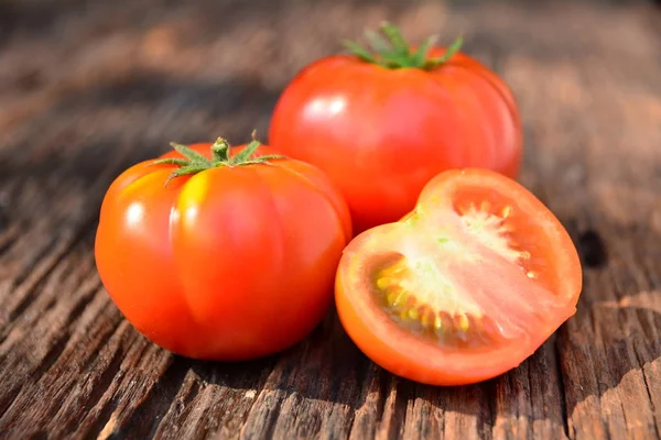 Fresh red tomato on old brown wood table at the morning — Stock Photo, Image