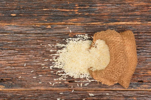 Beyaz pirinç çuvala ahşap arka plan üzerinde