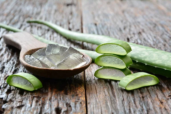 Aloë gel op houten lepel met Aloë gesneden op houten tafel. — Stockfoto