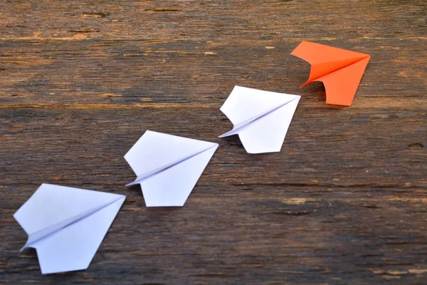 Αεροπλάνο χαρτί στο ξύλινο φόντο και πορτοκάλι είναι η ηγεσία — Φωτογραφία Αρχείου