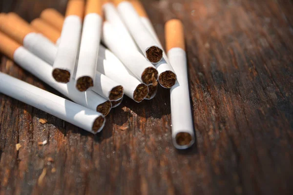 Cigarros de tabaco em fundo de madeira com luz brilha — Fotografia de Stock