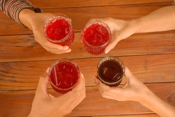 Hand av personer som innehar ett glas söt dryck med isbitar — Stockfoto