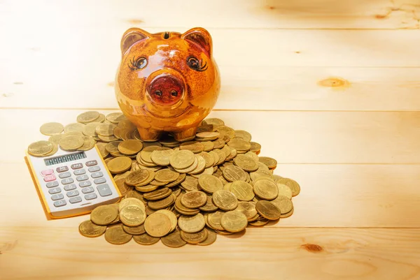 Stack coins, calculator and piggy bank on wood table and copy sp — Stock Photo, Image