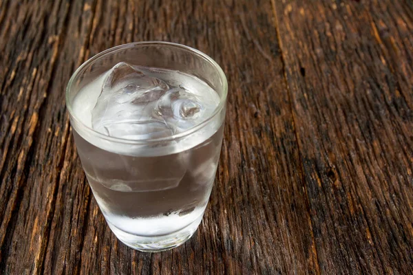 Agua helada en vidrio sobre mesa de madera para una salud saludable — Foto de Stock