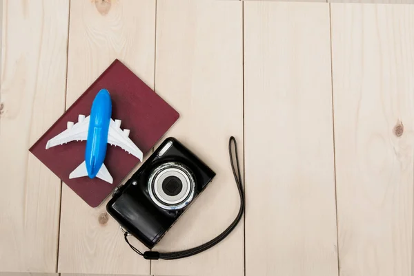 Camera met vliegtuig en notebook voor reizen houten tafel backg — Stockfoto