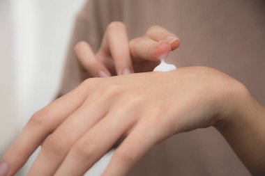 kadının el el ciltte losyon uygulamak.