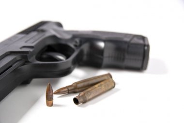 Beyaz arka plan üzerinde izole m-16 mermi ile oturan el silah.