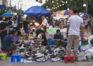 Arka plan bulanık. Bulanık insanlar bir market street yürüyüş.