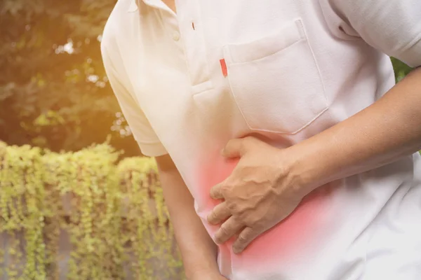 Hombre que sufre de dolor de estómago, un dolor de estómago hombre al aire libre, concepto saludable . —  Fotos de Stock