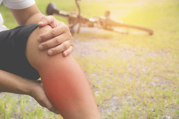 El tipo se aferra a una pierna mala. El dolor en la pierna después del ejercicio. El dolor se resalta en rojo . —  Fotos de Stock