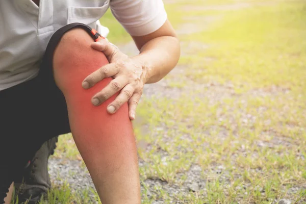 The guy clings to a bad leg. The pain in his leg after exercise. The pain is highlighted in red.