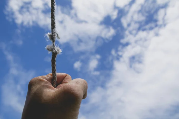 Handen om man håller på att repet är det nästan frånvarande under himmel. — Stockfoto