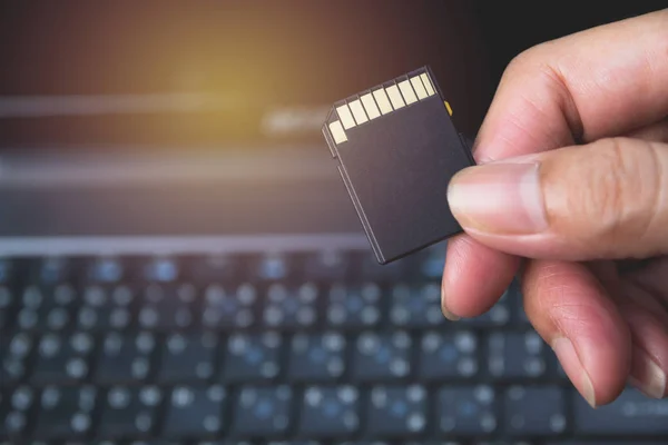 Photographer's hand holding memory card for preparing plug-in to computer. — Stock Photo, Image