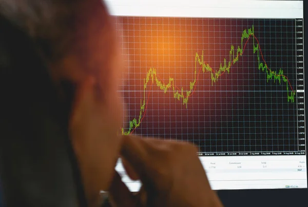 Uomo d'affari che cerca di indicatore grafico e barra del volume per l'analisi del mercato azionario su sfondo monitor. concetto di finanza aziendale . — Foto Stock
