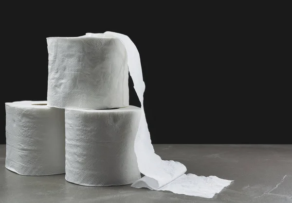 Bildstapel närbild av toalett papper rulla på bordet med mörk bakgrund. — Stockfoto