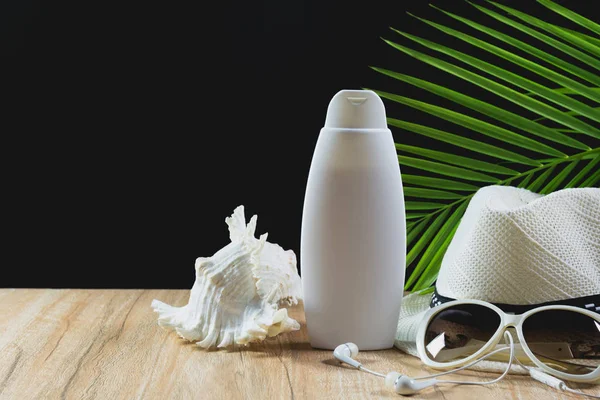 Travel stuff. Essential travel items. Sun glasses, white hat and sunscreen cream bottle on wooden table background.