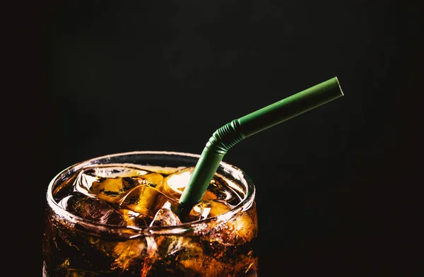 Tutup es cola glass. Air soda berkilau minuman di kaca dengan es di latar belakang gelap. — Stok Foto