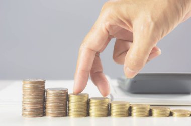 Masanın üzerine yığını sikkeler üzerinde yürüme el. Mali ve büyüyen iş kavramı.