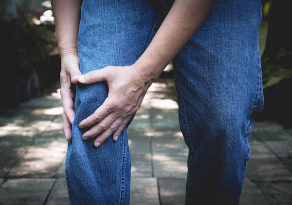 Dolor corporal. primer plano cuerpo masculino con dolor en las rodillas. Hombre manos tocando y masajeando dolorosa rodilla . — Foto de Stock