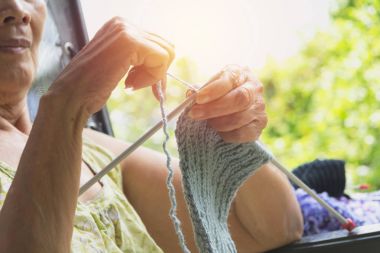 Yaşlı kadın yünlü giysiler dokuma kumaşlar. El örgü yakın çekim. Örgü iğneleri. 