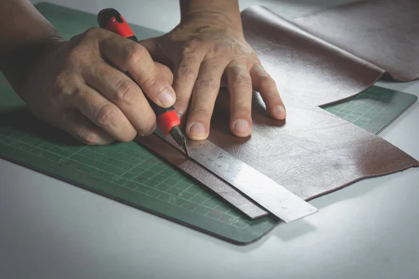 Primer plano del corte manual masculino con un cuchillo para el cuero para el bolso. Concepto de producto hecho en casa . —  Fotos de Stock