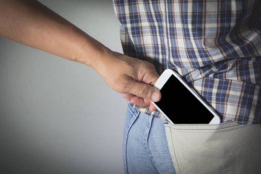 Yakın çekim, bir hırsız çalmak bir kadın akıllı telefona el. Bir kadının geri cep cep telefonu çalan hırsız.