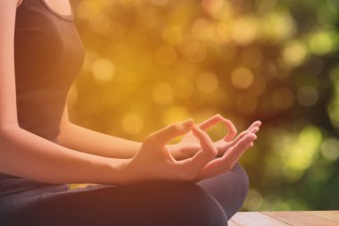 Kadınsı ve erkeksi kol ve doğa arka plan ile meditasyon sırasında çapraz bacak yakın çekim.