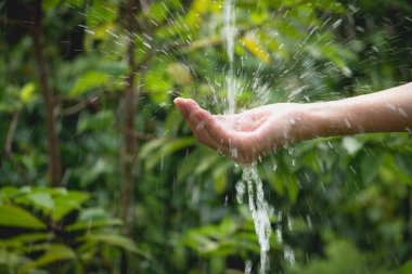 Kadın el doğa zemin üzerine dökülen su.