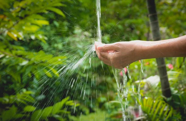 Kadın el doğa zemin üzerine dökülen su.