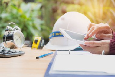 Mimar mühendis çalışma kavramı kask, çalar saat, dizüstü bilgisayar ve tablo araçları.