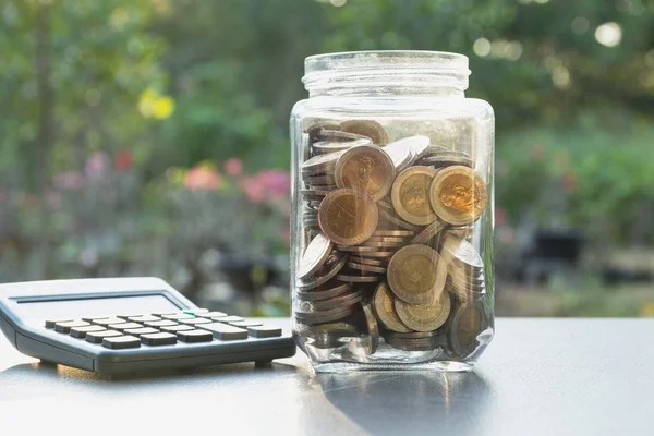 Saving money concept with money coin in the jar and calculator for business and accounting concept. — Stock Photo, Image