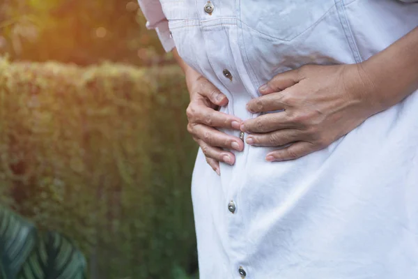 Hombre que sufre de dolor de estómago, un dolor de estómago hombre al aire libre, concepto saludable . — Foto de Stock