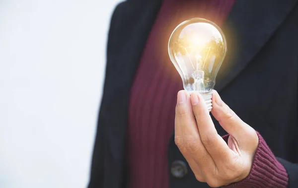 Main de femme d'affaires tenant ampoule pour l'idée ou le succès ou l'énergie solaire — Photo