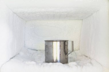 Buzdolabında paslanmaz çelik su bardağı var. Buzdolabının içinde buz birikiyor..