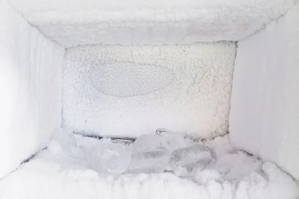 Vide d'un réfrigérateur. Accumulation de glace à l'intérieur des murs d'un congélateur . — Photo