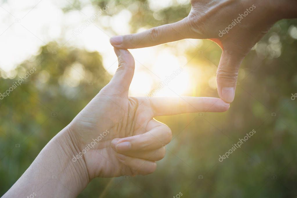 Close up of hands making frame gesture. Close up of woman hands making frame gesture with sunset.