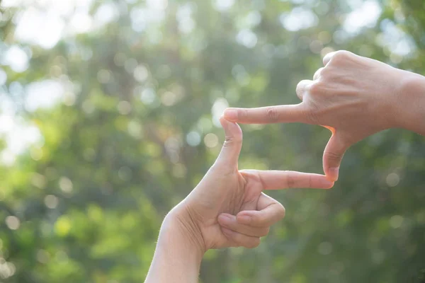 Close up of hands making frame gesture. Close up of woman hands making frame gesture with sunset.