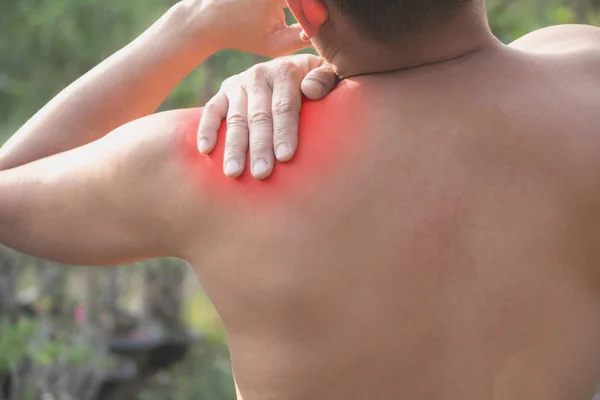 Hombre que sufre de dolor de hombro. Dolor agudo en un concepto muscular de hombre con mancha roja . —  Fotos de Stock