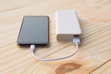 Güç banka üstünde okul sırası ile şarj mobil akıllı telefonlar.